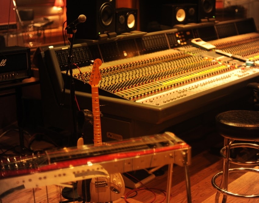 A picture of a pedal steel guitar and an analog recording console